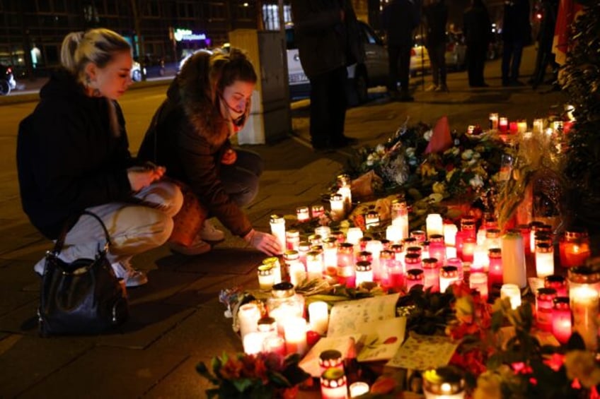 People placed candles at a makeshift memorial set up at the scene