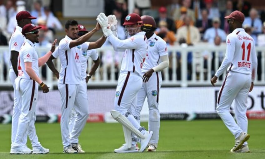 Success: West Indies spinner Gudakesh Motie (C/L) celebrates with teammates after dismissi