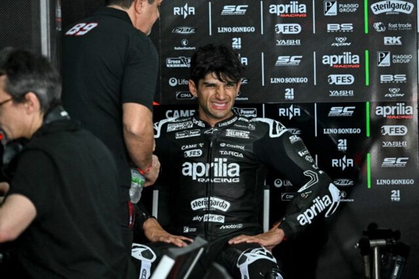 Jorge Martin winces in apparent discomfort in the Aprilia garage during the first day of t