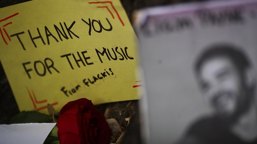 A sign that reads "Thank you for the music" next to a portrait of Liam Payne