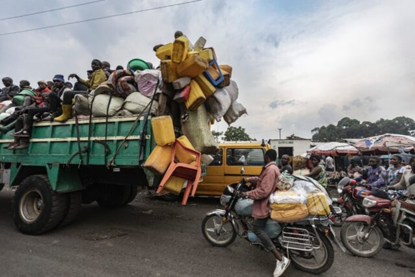 Internally displaced people travel with their belongings on a lorry as they leave camps in