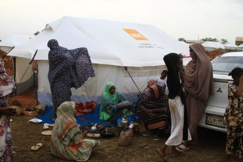 Women and children outside their tent at a camp for internally displaced at Gedaref in eas