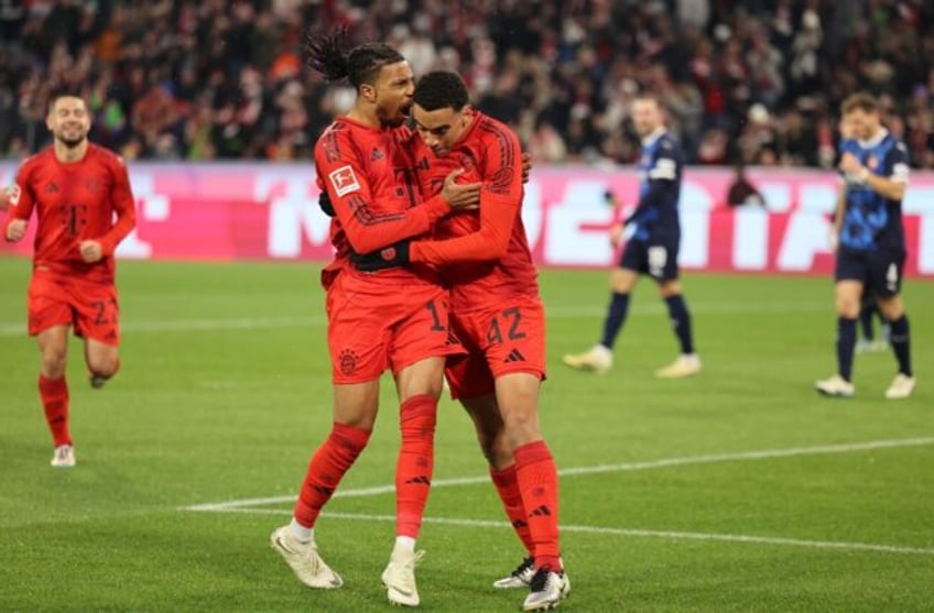 Bayern Munich forward Jamal Musiala (R) celebrates with Michael Olise