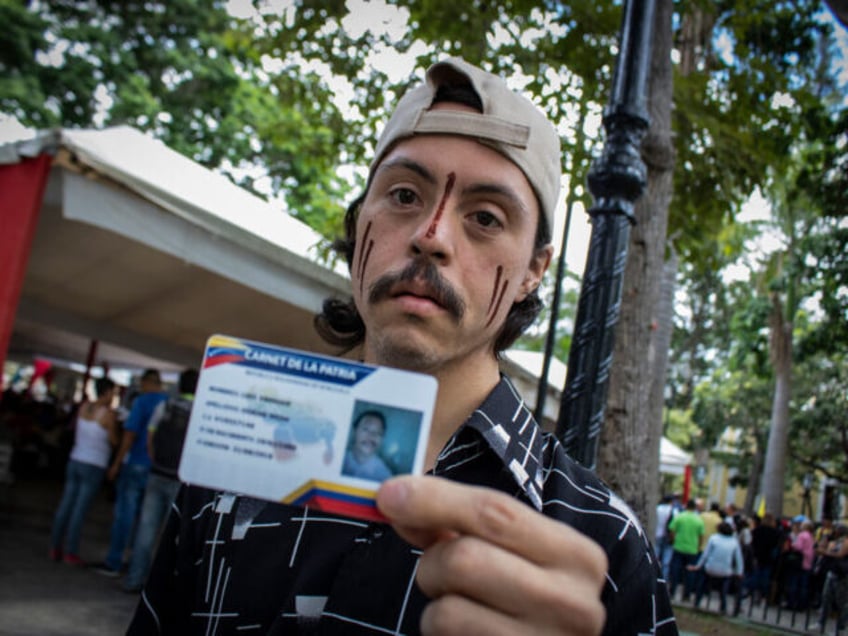 31.08.2018, Venezuela, Caracas: A man holds his new "Carnet de la Patria" (Fatherland identity card). Registered government supporters, welfare recipients and local public transport will be supported by direct subsidies. Photo: Rayner Pena/dpa (Photo by Rayner Pena/picture alliance via Getty Images)