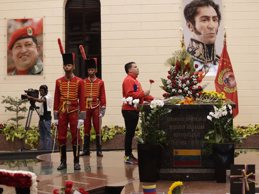 CARACAS, VENEZUELA - MARCH 5: Visitors pay their respects at the tomb of the late Venezuelan President Hugo Chavez during commemorations of the 10th anniversary of his death, outside the Cuartel de la Montana 4F where his remains are interred in Caracas, Venezuela, on March 5, 2023. Chavez died on March 5, 2013, after a long battle with cancer and chose the current president, Nicolas Maduro, a former bus driver and union leader to be his successor. (Photo by Pedro Rances Mattey/Anadolu Agency via Getty Images)