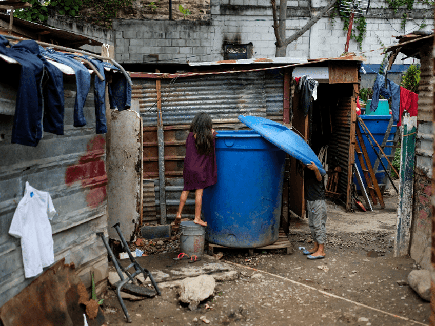 Children get water from a tank at the Petare neighborhood in Caracas on May 9, 2019. - Poo