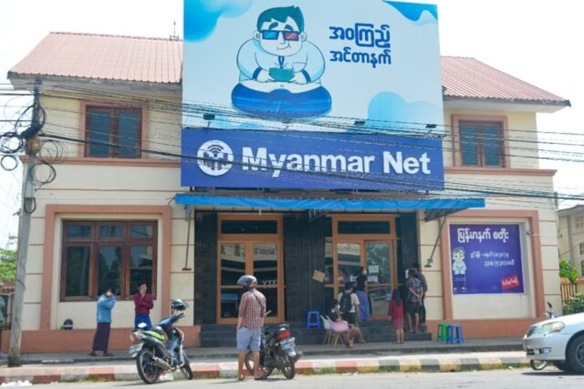 People wait outside an internet shop in Myanmar's capital Naypyidaw on March 16, 2021, sho