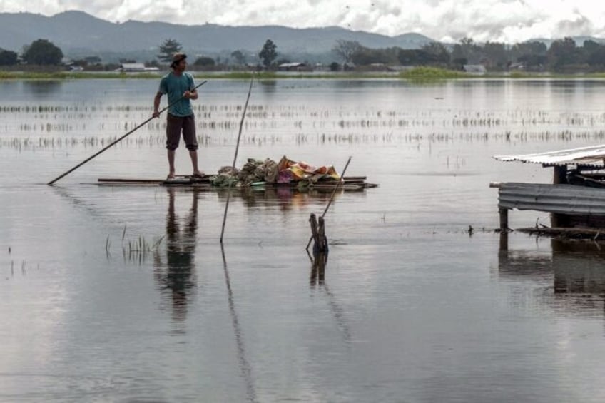 A man uses a raft on flood waters in Demoso township in Myanmar's Kayah state following he