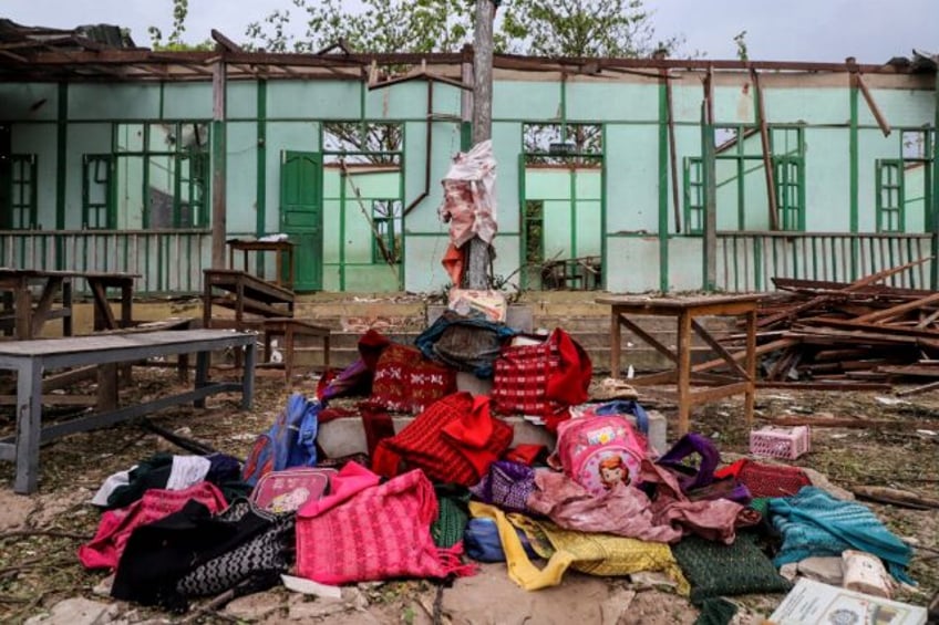 Over a dozen abandoned book bags were piled before a pole flying the Myanmar flag outside