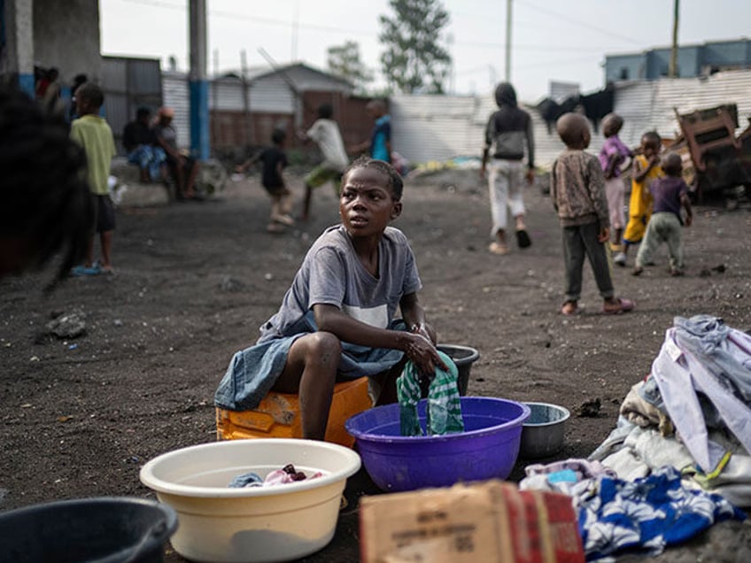 Laini, 11, washes clothes Tuesday, Feb. 18, 2025 in a Goma, eastern Congo school where she
