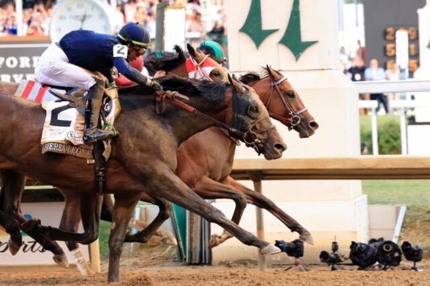 Mystik Dan, ridden by jockey Brian J. Hernandez Jr., crosses the finish line to win the 15