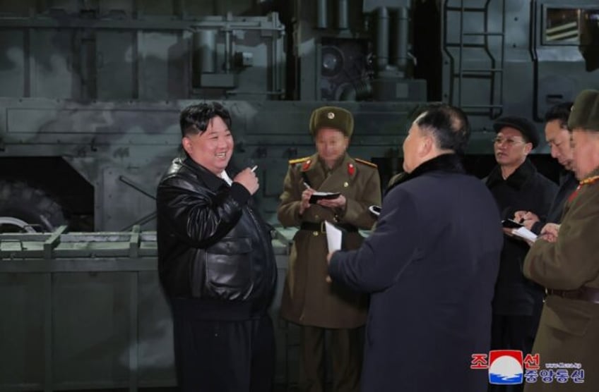 Kim Jong Un (L), seen inspecting a munitions factory, has called for constitutional changes allowing for South Korea's 'occupation' in event of war