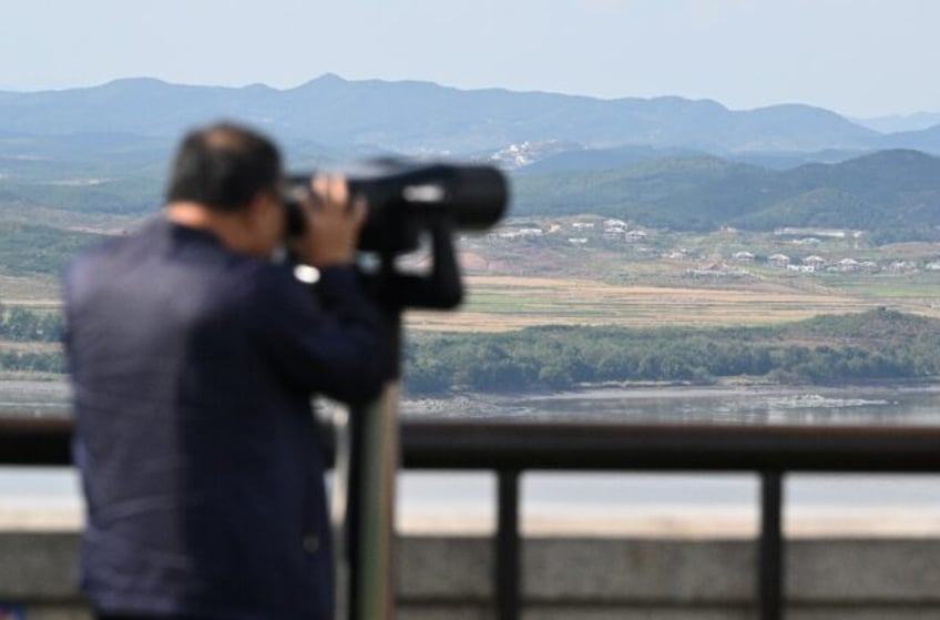 A man uses binoculars to look at the North Korean side of the Demilitarised Zone from Sout