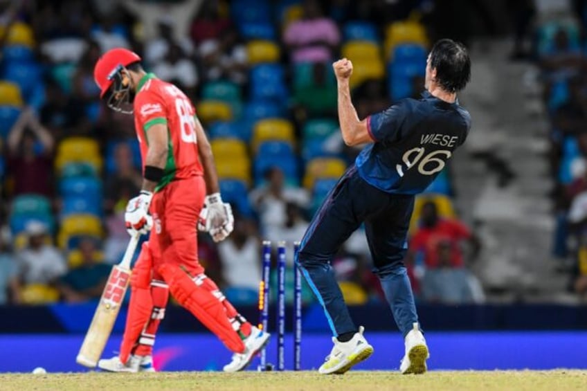 Oman's Naseem Khushi (L) is bowled by Namibia's David Wiese in the super over of their T20