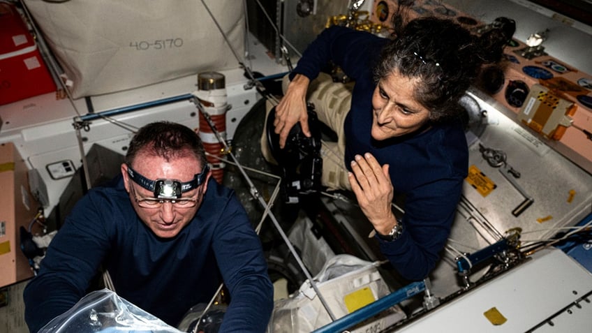 NASA astronauts Butch Wilmore, left, and Suni Williams inspect safety hardware aboard the International Space Station Aug. 9.