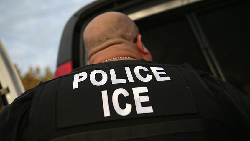 ice AGENT seen from behind in black shirt