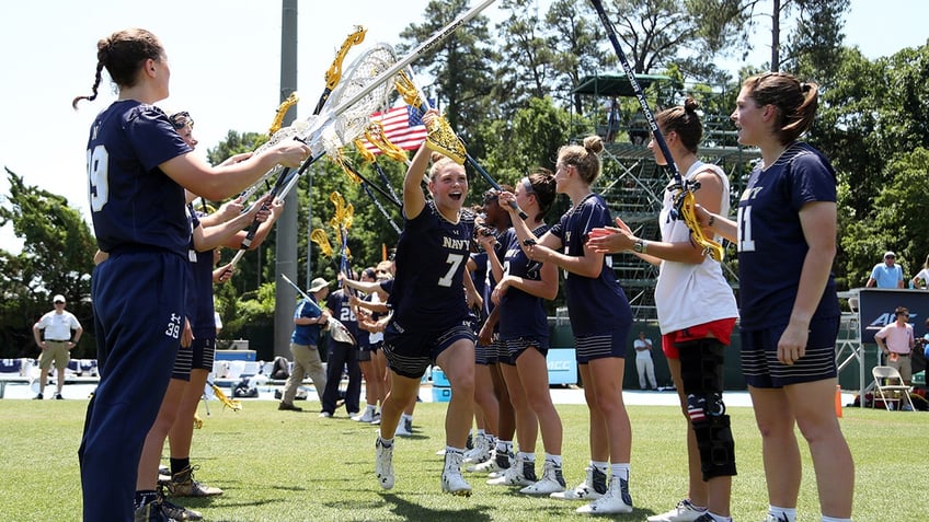 Naval Academy lacrosse team runs on field