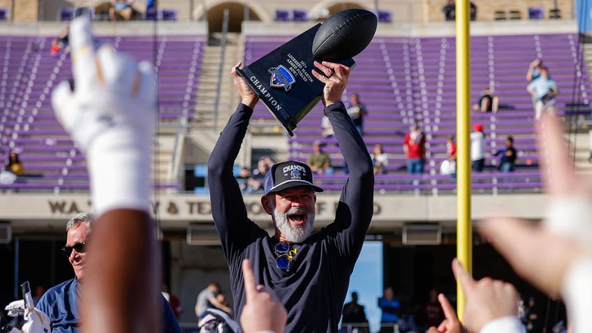 Brian Newberry raises trophy