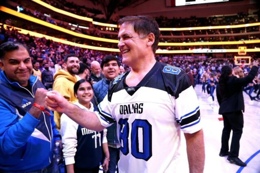 Mark Cuban bumps fists with a fan after an NBA game between the Dallas Mavericks and Los Angeles Lakers. His sale of controlling interest in the club has been approved by the league