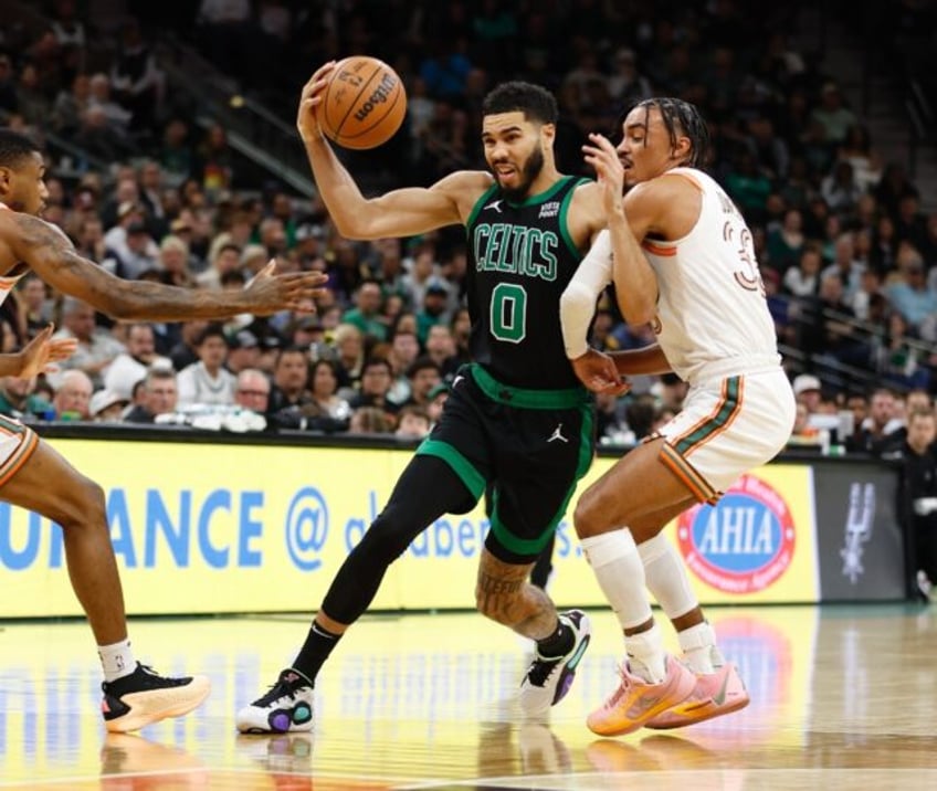 Boston's Jayson Tatum, at left driving to the hoop against San Antonio's Tre Jones, scored 25 points to lead the NBA-best Celtics over the Spurs 134-101