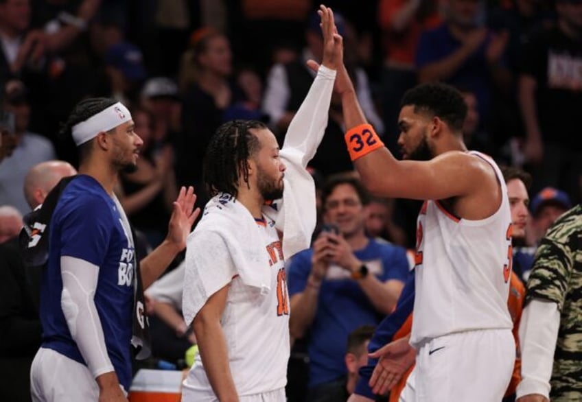 Jalen Brunson (center) high fives with teammate Karl-Anthony Towns as the New York Knicks