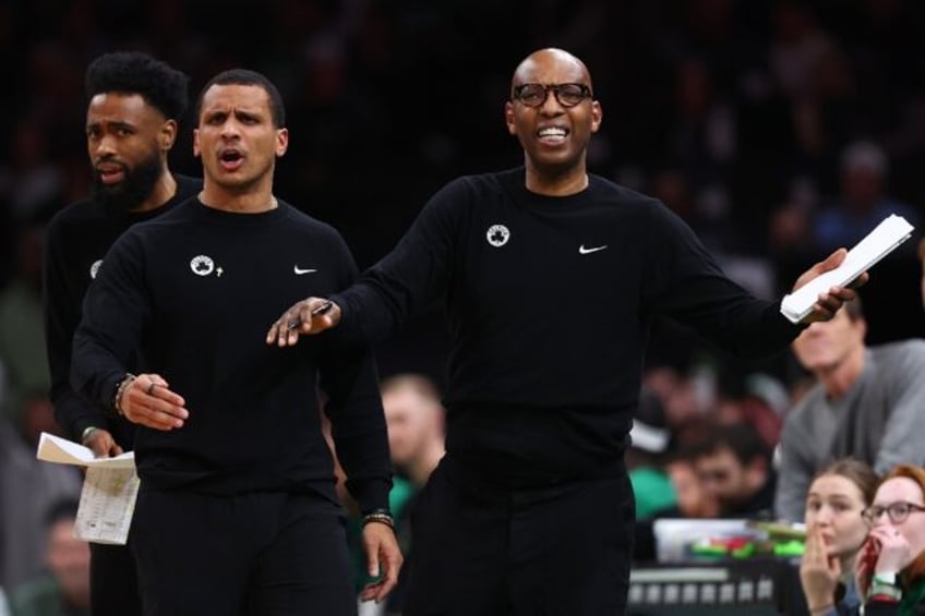 Boston Celtics head coach Joe Mazzulla, left, is held back by assistant coach Sam Cassell