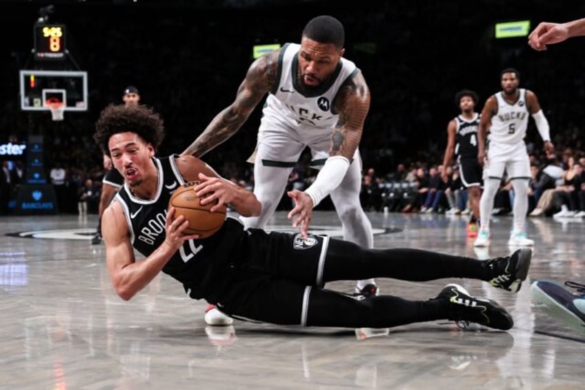 Brooklyn's Jalen Wilson grabs the ball from Milwaukee's Damian Lillard during a Bucks NBA road victory in December, a game for which the Nets have been fined $100,000 for violating the NBA's Player Participation Policy