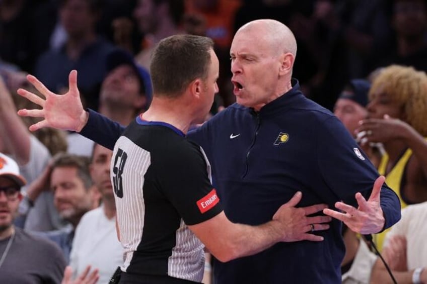 Indiana Pacers head coach Rick Carlisle, at right arguing a call with referee Josh Tiven,