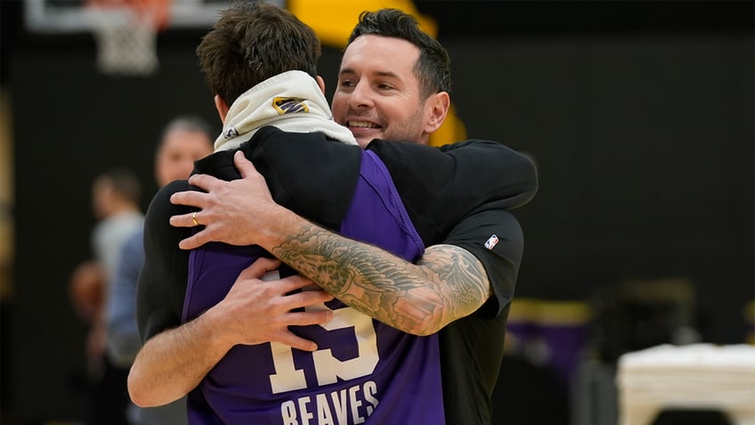 JJ Redick is hugged by Austin Reaves