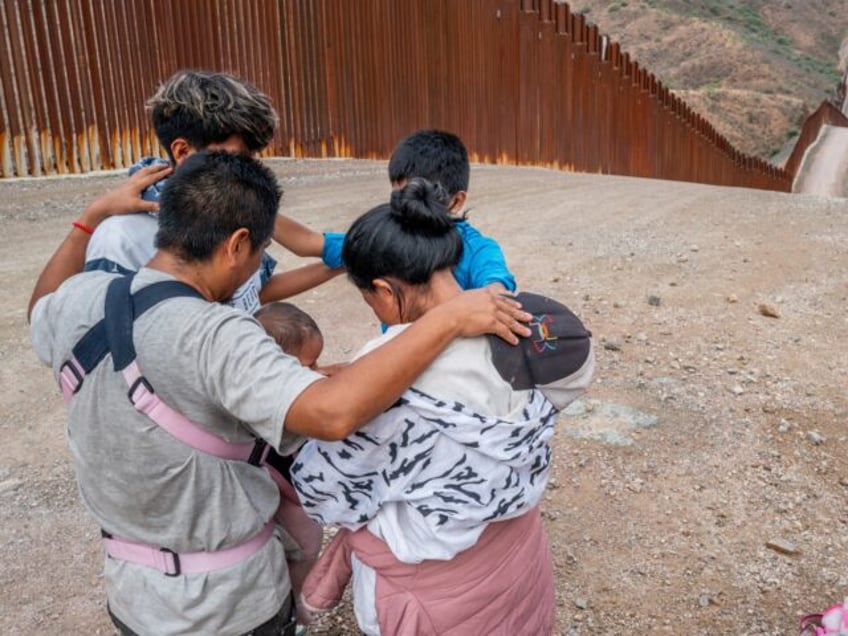 A migrant family seeking asylum from Ecuador pray together while waiting to be apprehended