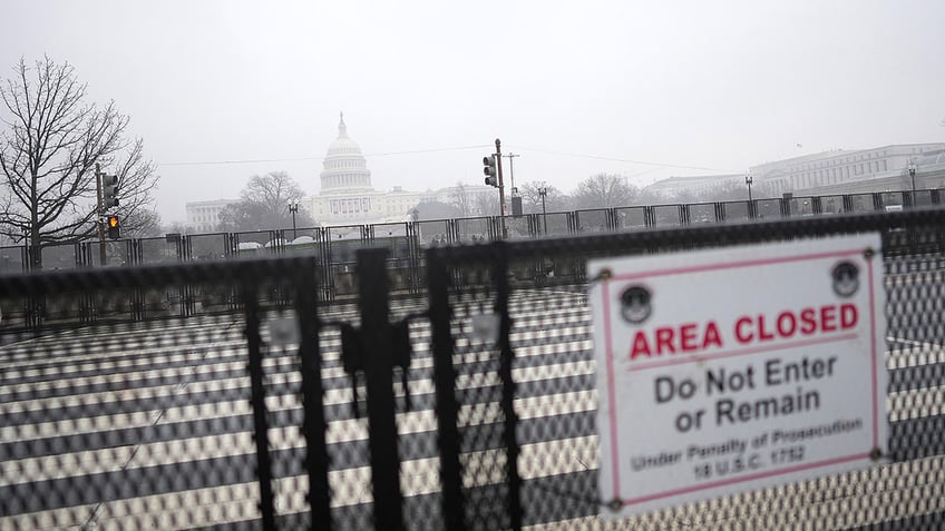 Fencing with US Capitol in background on foggy day