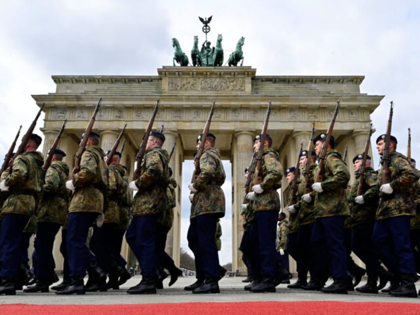 Members of a German honor guard march past the Brandenburg Gate in Berlin as they rehearse for the arrival of Britain's King Charles III and Britain's Camilla, Queen Consort, expected to attend a ceremonial welcome, on March 29, 2023. - Britain's King Charles III will begin his first state visit, …