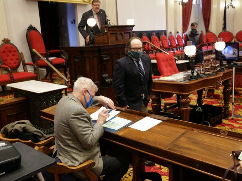 Terje Anderson, left, one of the three members of Vermont's Electoral College, casts his v