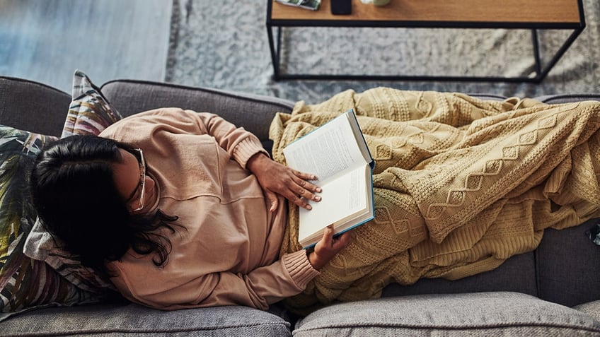 woman reads on the couch