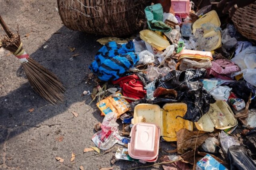 Lagos State Waste Management Authority (LAWMA) staff cleans up piled up waste from the roa