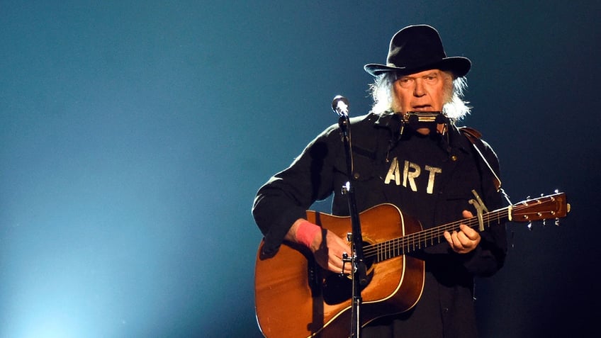 Neil Young playing guitar onstage