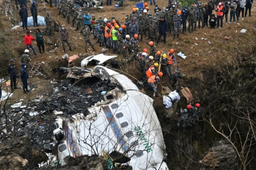 Rescuers pull the body of a victim who died in a Yeti Airlines plane crash in Nepal in January 2023