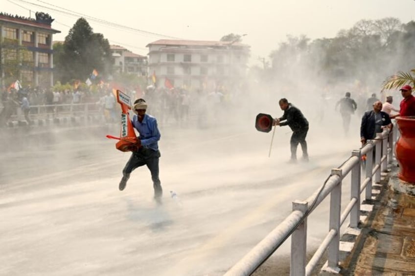 Nepali security personnel use water cannon to disperse pro-monarchy protesters, as dissati