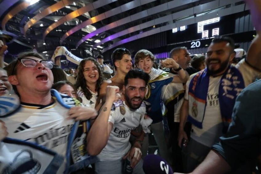 Real Madrid fans celebrate their team's victory outside the Santiago Bernabeu stadium in M