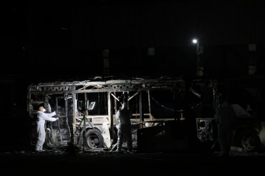 Security forces and bomb disposal units are deployed to the scene of a bus explosion in Ba