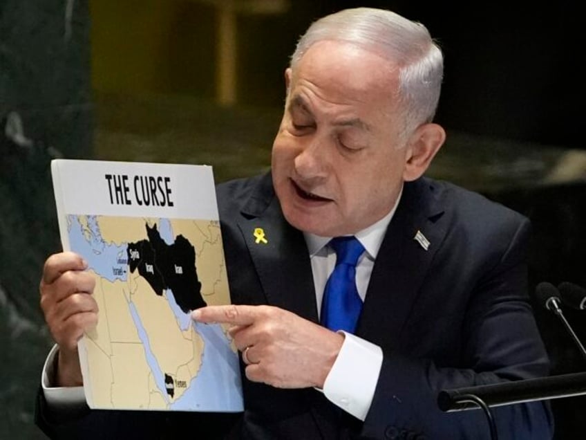 Prime Minister of Israel Benjamin Netanyahu hold a sign as he addresses the 79th session o