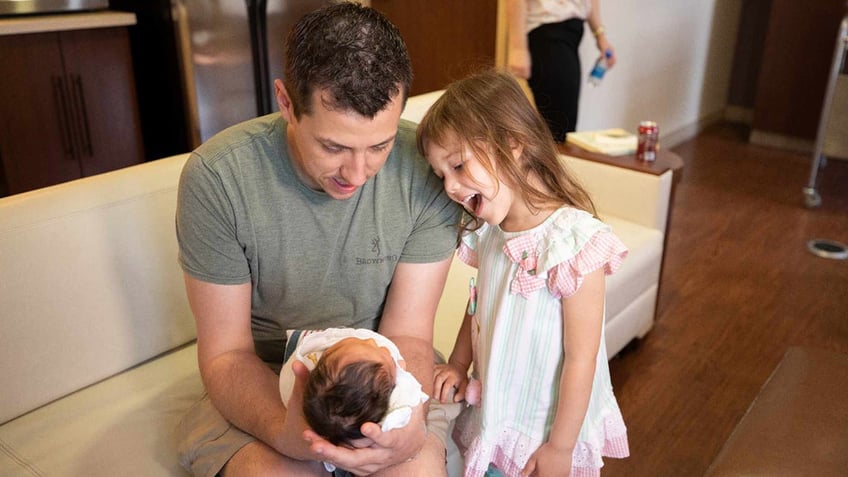 dad holding baby little girl looking amazed