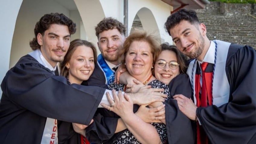 Siblings hugging mother