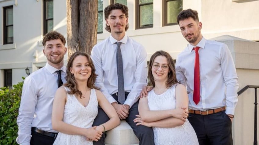 Graduating siblings dressed in white