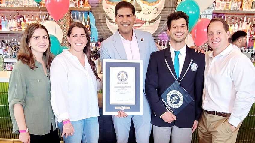 Five smiling people with world record