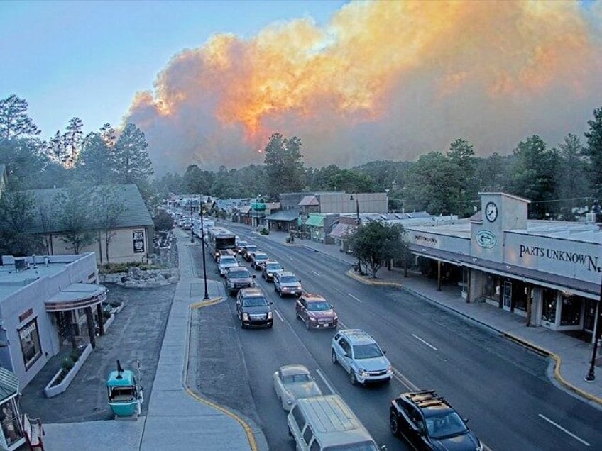 In this image taken from webcam footage provided by the Village of Ruidoso, smoke rises be
