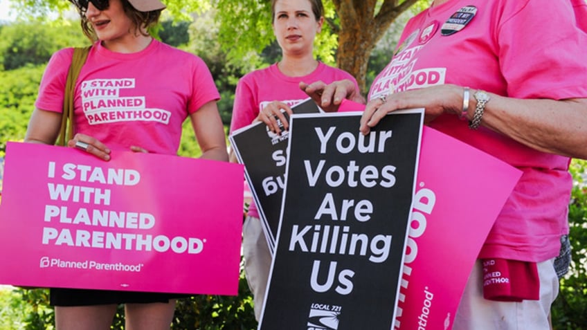 Supporters of Planned Parenthood hold signs during a rally to fight back against the U.S. House of Representatives' vote to repeal the Affordable Care Act held outside of the office of Congressman Steve Knight in Santa Clarita, Los Angeles, California, U.S., May 4, 2017. REUTERS/Andrew Cullen - RTS158CA