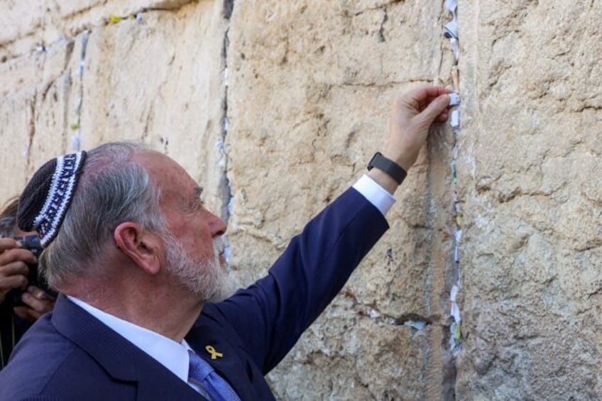 United States ambassador to Israel Mike Huckabee places a note given to him by US Presiden