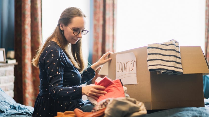 woman putting clothes in box