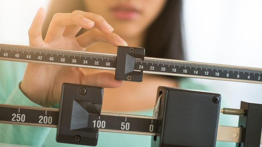 Woman adjusting scale